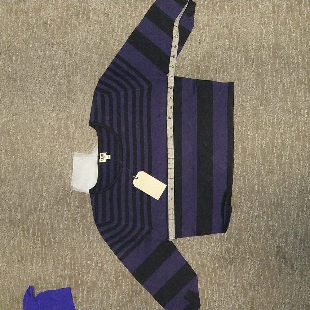 UNIQ clothing brand crop top three quarter length sleeves.